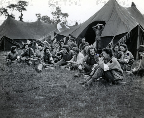 Group of U.S. Army nurses, first to land with the vanguard of American troops, eating dinner at field hospital, Normandy, France, U.S. Army Signal Corps, June 15, 1944