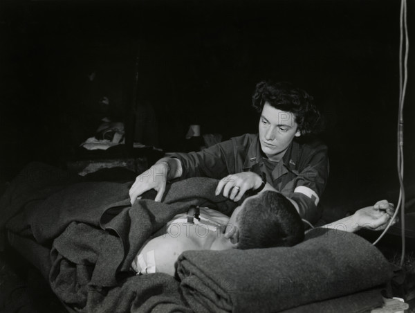 Lt. Ann Howe, Boston, Massachusetts, a U.S. Army nurse, attending a G.I. with lung wound in an evacuation hospital, Normandy, France, U.S. Army Signal Corps, July 3, 1944