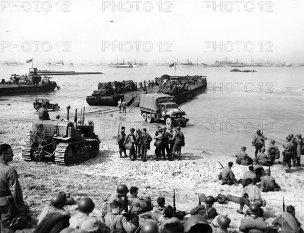 Rhine ferry unloading vehicles and troops on 6th Engineer Special Brigade Beach at Omaha Beach, Normandy, France, Steck, U.S. Army Signal Corps, August 4, 1944