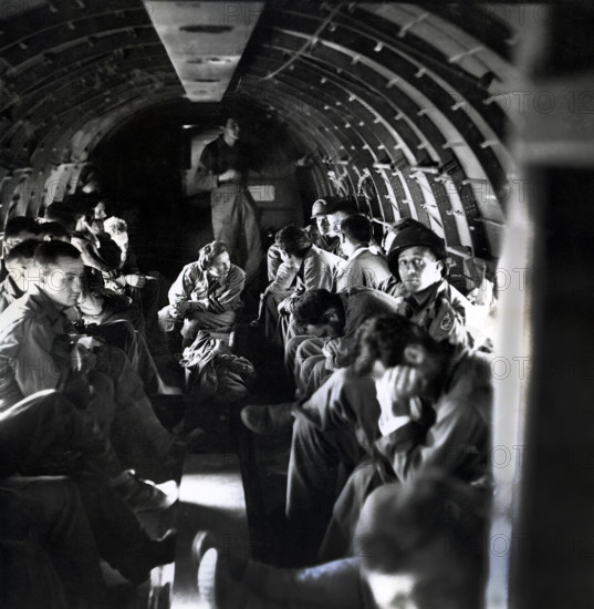 Nurse with wounded American soldiers on C-47 airplane crossing English Channel from Normandy, France, U.S. Army Signal Corps, June 1944