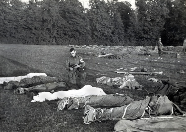 U.S. Army Chaplain Francis L. Sampson of Sioux Falls, S.D., giving absolution to American paratroopers killed in action, Saint Marie Dumont, France, Runyan, U.S. Army Signal Corps, June 7, 1944