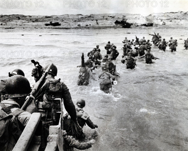 American troops plunge into surf and wade shoreward carrying equipment, Utah Beach, La Madeleine, Normandy, France, Shelton, U.S. Army Signal Corps, June 6, 1944