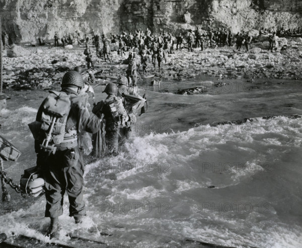 American troops wading through surf before joining additional troops on beachhead, Normandy, France, U.S. Army Signal Corps, June 12, 1944