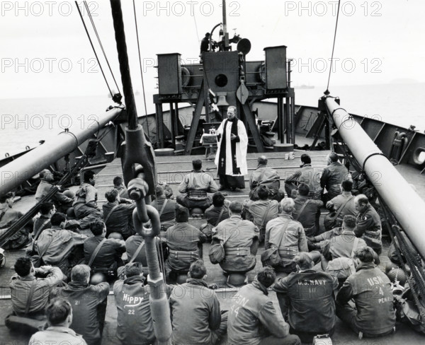 Chaplain Louis R. Goodrich, San Antonio, Texas, conducting religious services aboard an invasion-bound ship, Normandy, France, U.S. Army Signal Corps, June 12, 1944