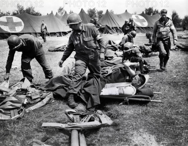 U.S. Army medics making their patients comfortable and begin to distribute life belts to them at a beachhead field hospital in Normandy, France, while they wait to be loaded onto LST's for the return trip to England, U.S. Army Signal Corps, June 11, 1944