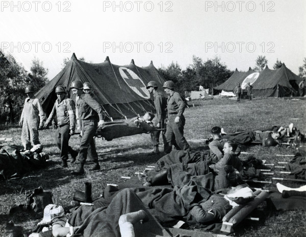 American Medics of 8th Infantry Regiment, 4th Infantry Division, bringing American and British casualties from beachheads to field hospital, Normandy, France, Shelton, U.S. Army Signal Corps, June 6, 1944