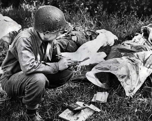 U.S. Sergeant Peter F. Slusarezyk, attached to the Medical Department, tagging a dead American soldier, Sainte-Mere-Eglise, France, U.S. Army Signal Corps, June 7, 1944