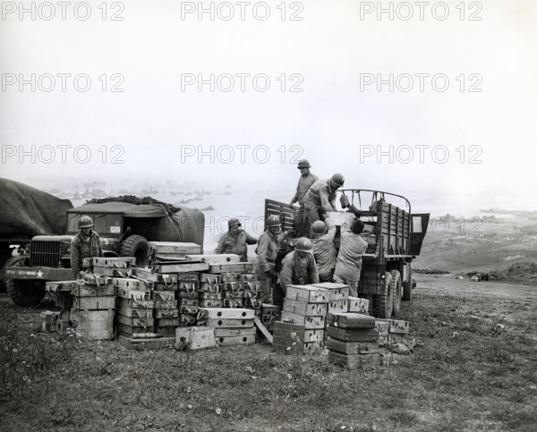 American members of 616th Ordnance Company load ammunition for the famed German 88 gun onto a truck to be salvaged, Omaha Beach, Normandy, France, U.S. Army Signal Corps, June 20, 1944