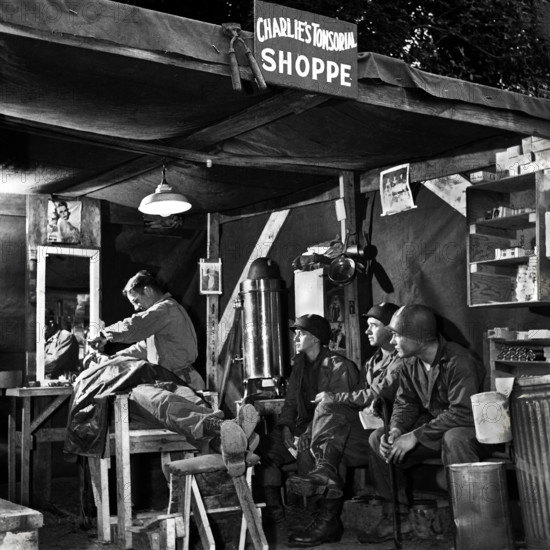 American soldiers wait their turn at Charlie's Tonsorial Shoppe, Normandy, France, U.S. Army Signal Corps, 1944