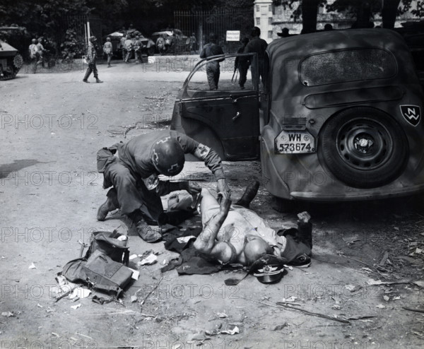 American medic giving first aid to wounded German officer, Chartres, France, U.S. Army Signal Corps, August 15, 1944