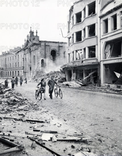 Residents move past bombed buildings hit by German Luftwaffe in an attempt to destroy bridge over Meuse River to delay advance of Allied forces, Verdun, France, U.S. Army Signal Corps, September 2, 1944