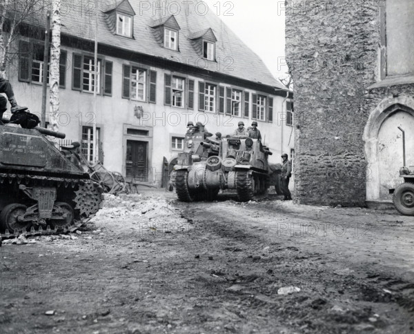Tank of U.S. 9th Armored Division, U.S. First Army, rolling through street of Limburg, Hesse, Germany, MacDonald, U.S. Army Signal Corps, March 29, 1945