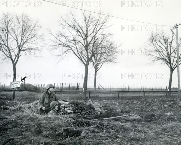James E.J. Jentry of Bristol, Tennessee and Pfc. John W. Harris of Portland, Oregon, infantrymen of 1st Infantry Division, U.S. First Army, on alert in their foxhole, Pingsheim, North Rhine-Westphalia, Germany, U.S. Army Signal Corps, March 2, 1945