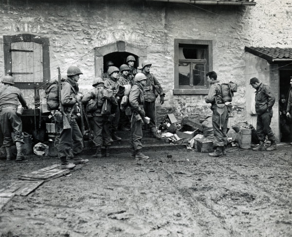 U.S. infantrymen of 16th regiment, 1st Division, U.S. First Army, making final preparations and getting briefed before crossing Roer River, Schneidhausen, North Rhine-Westphalia, Germany, U.S. Army Signal Corps, February 25, 1945
