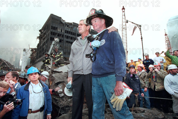 U.S. President George W. Bush standing atop burned out emergency vehicle with retired New York City firefighter Bob Beckwith at collapsed World Trade Center site, Financial District, Manhattan, New York City, New York, USA, Paul Morse, George W. Bush White House Photo Office, September 14, 2001