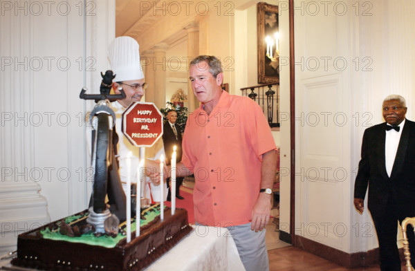 U.S. President George W. Bush being presented with birthday cake at his birthday party, White House East Room, Washington, D.C., USA, George W. Bush White House Photo Office, July 4, 2005