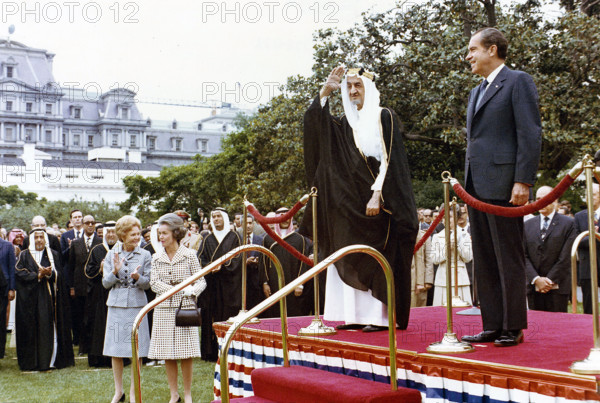 U.S. President Richard Nixon and King Faisal of Saudi Arabia standing on dais with U.S. First Lady Pat Nixon looking on from left during White House arrival ceremony for King Faisal at the White House, Washington, D.C., USA, Richard Nixon White House Photo Office, May 27, 1971