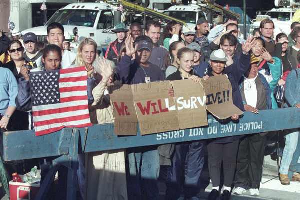 Onlookers waving and holding American flag and sign reading "We Will Survive" during U.S. President George W. Bush's visit to World Trade Center disaster site, Financial District, Manhattan, New York City, New York, USA, Paul Morse, George W. Bush White House Photo Office, September 14, 2001