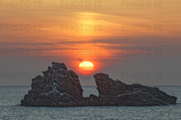 France, Manche (50) Omonville-la-Rogue, la pointe de Jardeheu l'anse ST-Martin au soleil se couchant entre deux rochers / France, Manche Omonville-la-Rogue, the Jardeheu point, the ST-Martin cove at sunset between two rocks /