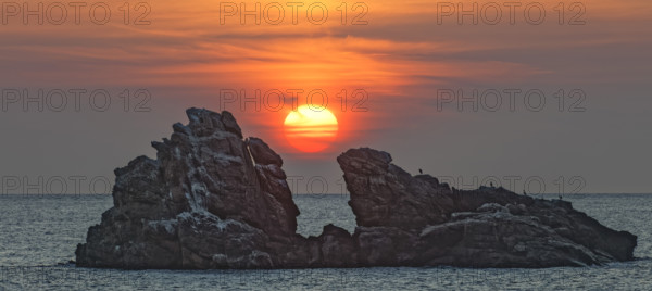 France, Manche (50) Omonville-la-Rogue, la pointe de Jardeheu l'anse ST-Martin au soleil se couchant entre deux rochers / France, Manche Omonville-la-Rogue, the Jardeheu point, the ST-Martin cove at sunset between two rocks