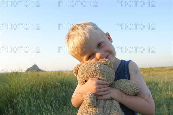 France, Normandie, Manche, baie du Mont-Saint-Michel, enfant de 4 ans Felix et doudou, ours en peluche, champ, personnage autorise,