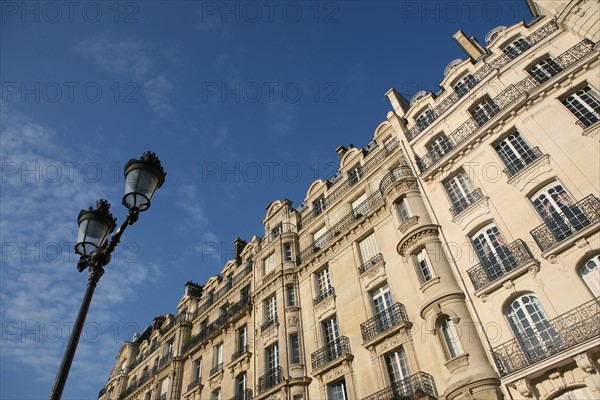 France, Paris 4e, ile de la cite, quai aux fleurs, immeuble, lampadaire, ciel bleu legereent nuageux,