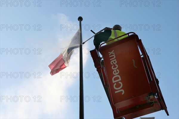 France, Paris 9e, JC Decaux, nettoyage sous pression d'un drapeau