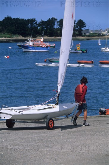 France, Bretagne, Finistere nord, cotes des abers, l'aber wrac'h, ecole de voile, marin portant son bateau,