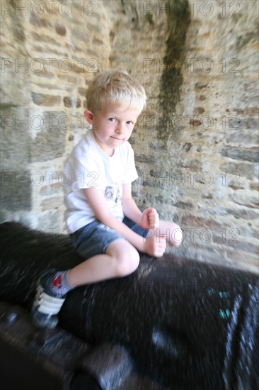 France, Bretagne, Finistere sud, Cornouaille, Concarneau, la ville close, fortification vauban, enfant 6 ans jouant sur un canon, personnage ok,