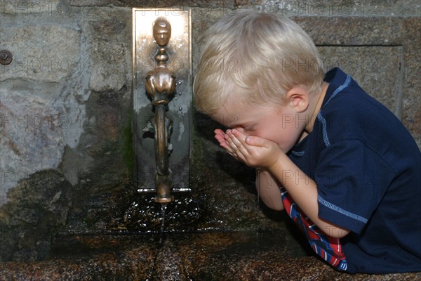 France, Basse Normandie, Manche, pays de la baie du Mont-Saint-Michel, enfant de 6 ans buvant de l'eau a une fontaine, personnage ok,