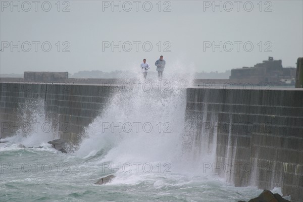 France, Basse Normandie, Manche, Cotentin, Cherbourg, grande rade ouest, querqueville, tempete, gerbes d'eau sur la digue, jogging, personnages qui courent,