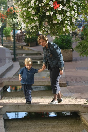 France, Haute Normandie, Seine Maritime, Rouen, rue eau de robec, jeune femme et enfant de 3 ans, personnages ok, ruisseau, fleurs, maisons a pans de bois, colombage, medieval, habitat traditionnel,