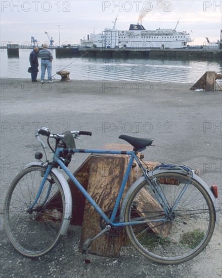 France, Basse Normandie, Manche, Cotentin, Cherbourg, port de commerce, velo pose, pecheurs a la ligne, ferry fumant au fond, quai,