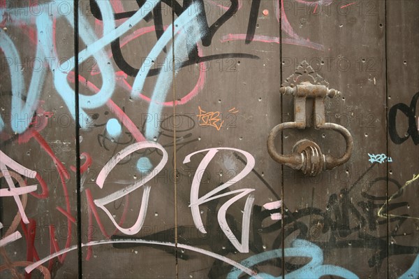 France, languedoc roussillon, gard, uzes, maison ancienne, heurtoir de porte et graffiti sur la porte, environnement, salete, pollution,