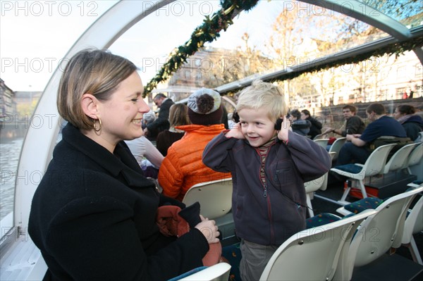 France, Alsace, Bas-Rhin, Strasbourg, croisiere fluviale sur l'Ill pendant la periode des marches de Noel, maisons sur les quais habitat traditionnel, la Petite France, audioguidage, femme et enfant 4 ans, personnage autorise