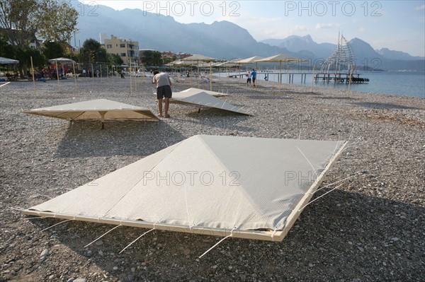 Turquie, sud d'antalya, kemer, riviera turque, station balneaire, debut de saison touristique, hotel, plage au pied des montagnes, preparation de la grande saison, hotel, parasols en cours de montage,