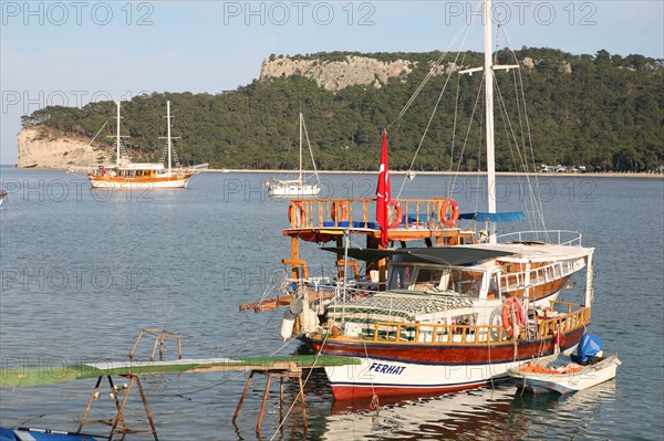 Turquie, sud d'antalya, kemer, riviera turque, station balneaire, debut de saison touristique, hotel, plage au pied des montagnes, preparation de la grande saison, promenade, tourisme, vide de touristes, pecheur a la ligne, goelettes, bateaux, anse,