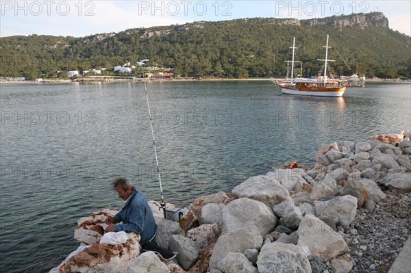 Turquie, sud d'antalya, kemer, riviera turque, station balneaire, debut de saison touristique, hotel, plage au pied des montagnes, preparation de la grande saison, palmier, promenade, tourisme, vide de touristes, pecheur a la ligne, goelettes, bateaux, an