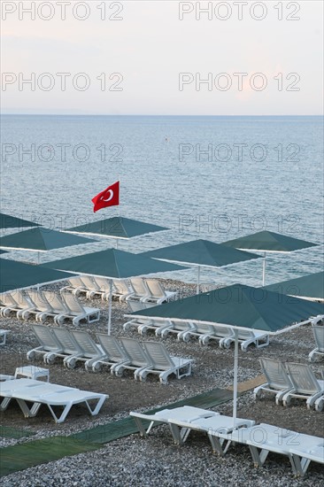 Turquie, sud d'antalya, kemer, riviera turque, station balneaire, debut de saison touristique, hotel, plage au pied des montagnes, preparation de la grande saison, piscine, transat, tourisme, vide de touristes, club, hotel, galets, drapeau turc,