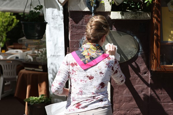 France, Basse Normandie, calvados, cote fleurie, houlgate, bord de mer, restaurant, nettoyage de l'enseigne, femme, chignon, restaurant,