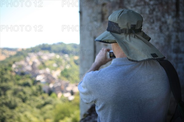 france, region midi pyrenees, aveyron, najac, village sauvegarde, chateau, forteresse, moyen age, vieilles pierres, patrimoine, histoire, interieur du chateau, panorama sur le village, sommets, senior, touriste prenant des photos,