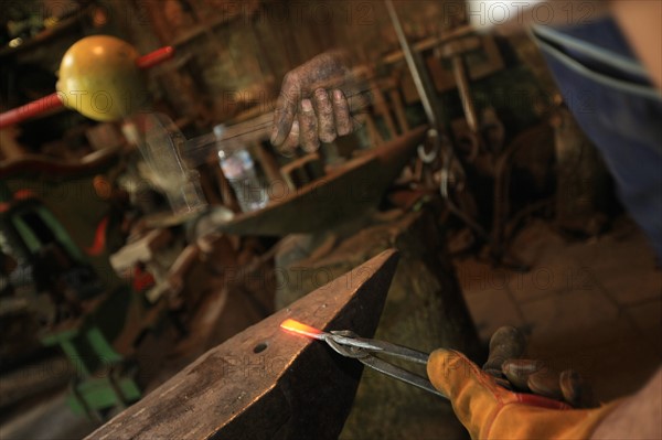 france, region midi pyrenees, tarn et garonne, 82, gorges de l'aveyron, espinas, forge, a force d'en fer, arnaud elisabeth artiste et forgeron, feu, metal, travail, marteau et main suspendus,