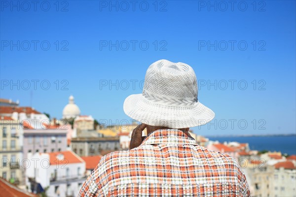 portugal, lisbonne, lisboa, signes de ville, alfama, panorama sur toits et le tage, senior avec chapeau et chemise associees au paysage, toits
Date : septembre 2011