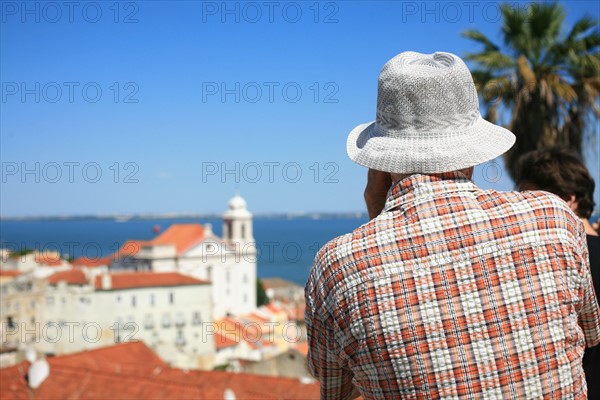 portugal, lisbonne, lisboa, signes de ville, alfama, panorama sur toits et le tage, senior avec chapeau et chemise associees au paysage, toits
Date : septembre 2011