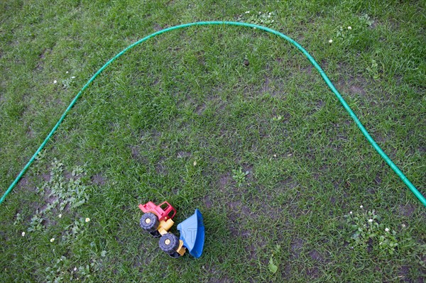 Allemagne (Germany), Berlin, Prenzlauer Berg, Gaudy Strasse, tuyau d'arrosage et jouet dans un parc pour enfants,