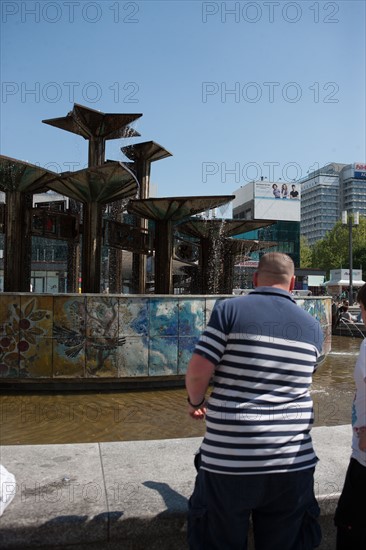 Allemagne (Germany), Berlin, Alexanderplatz, Tour Fernsehturm, tour de television de Berlin Est, fontaine et pull raye,