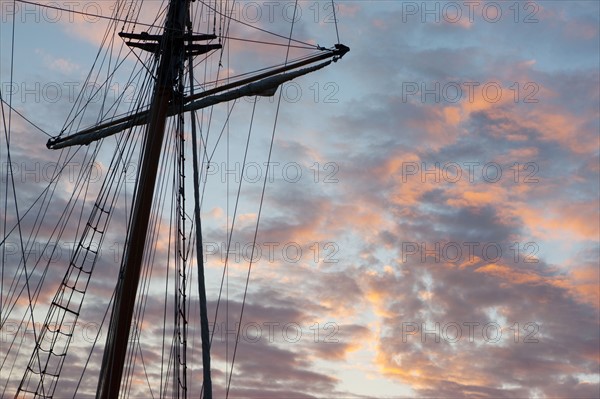 France, région Pays de la Loire, Loire Atlantique, Pornic, mât et cordages d'un voilier se détachant sur les nuages au crépuscule.