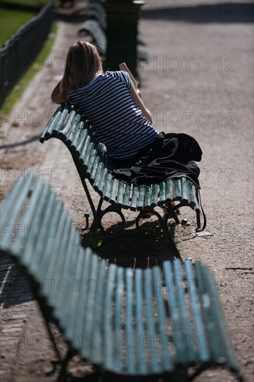 France, Région Ile de France, Paris 8e arrondissement, Parc Monceau, jeune femme en pull rayé et banc public