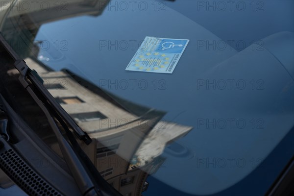 Paris, handicapped parking card behind a windshield