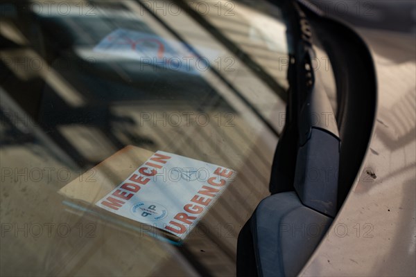 Paris, carte de médecin urgentiste sous un pare-brise de voiture